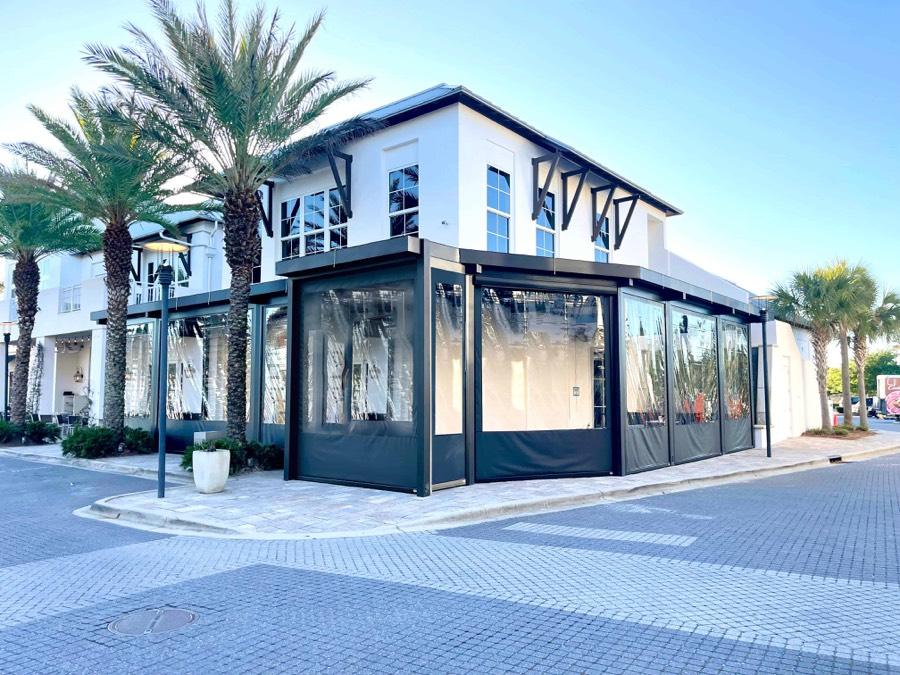 Clear panels enclosing a restaurant patio on a plaza corner