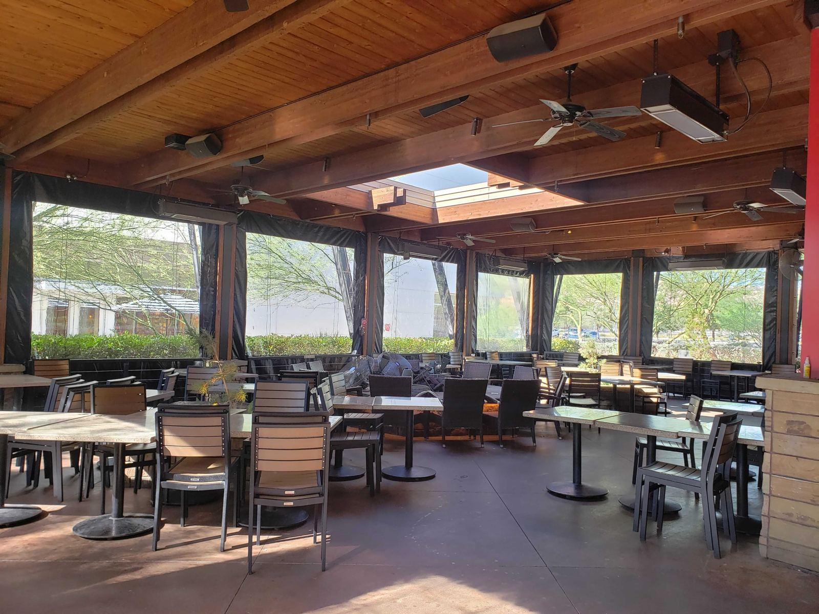 Lazy Dog patio in Las Vegas, clear panels down under a timber roof with dining tables inside