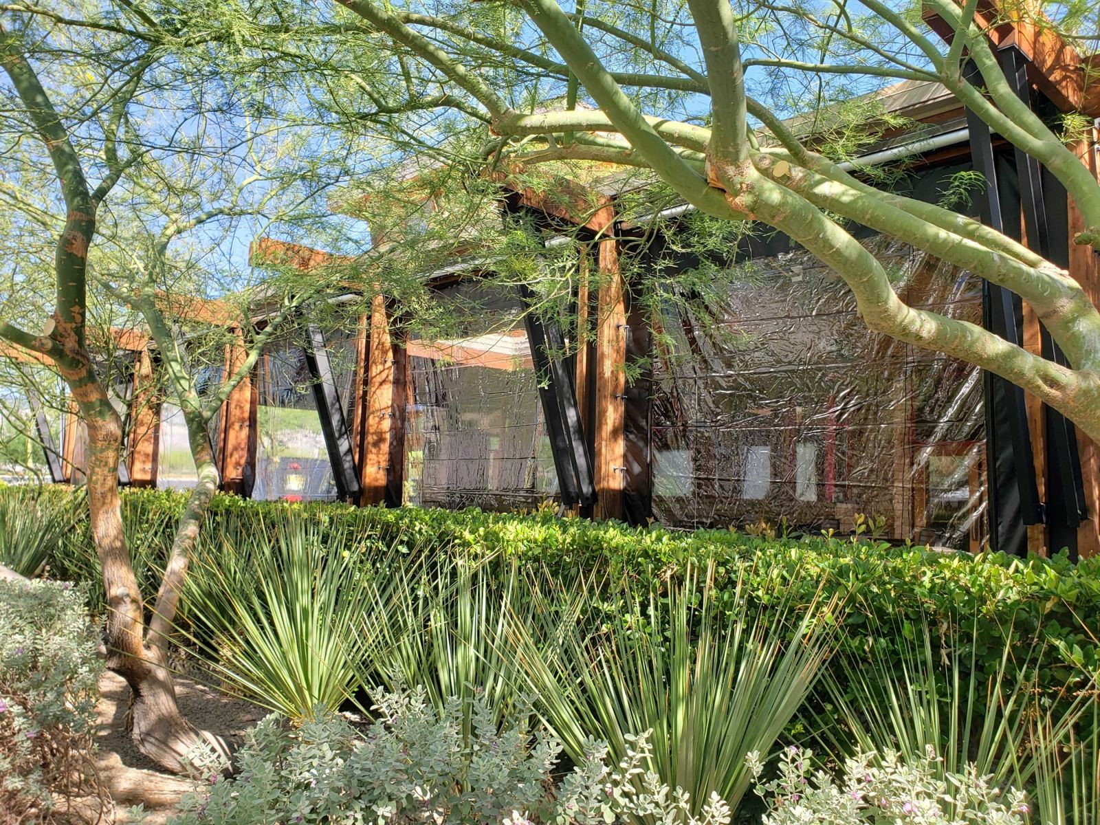 The same Las Vegas patio from the garden side, clear panels framed in timber