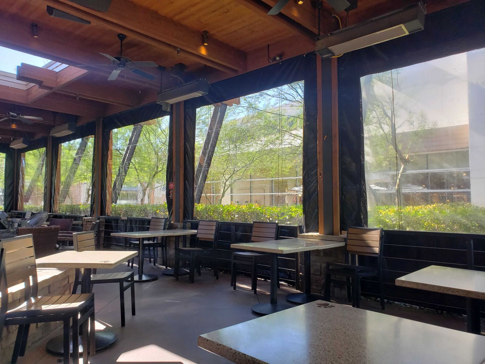 Tables inside the enclosed patio with the clear panels down
