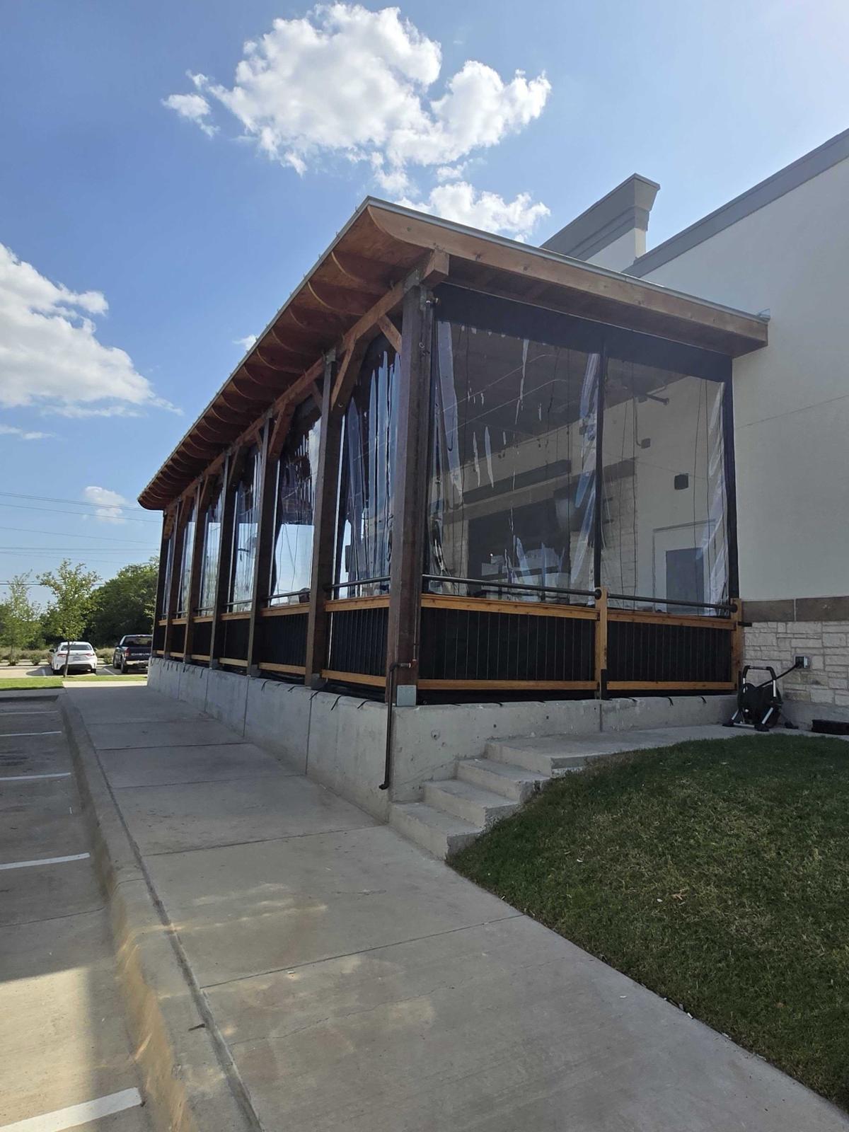 Outside view of a patio enclosed with manual roll clear panels