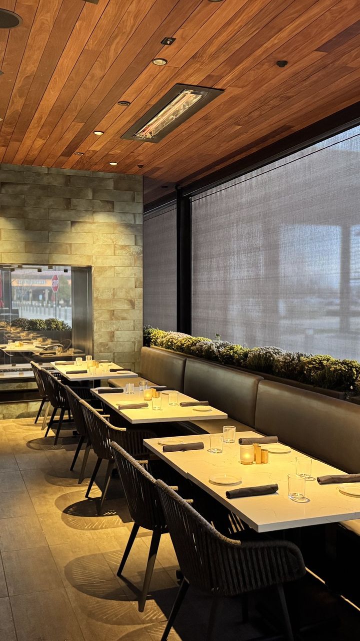 Perry's Steakhouse patio dining room in Schaumburg, Illinois, motorized sun shades down along the tables, the view still showing through