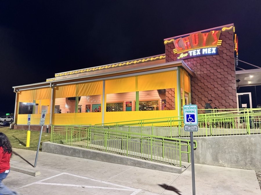 Chuy's Abilene at night: the patio closed in Chuy's yellow motorized curtains with clear windows, the neon sign above