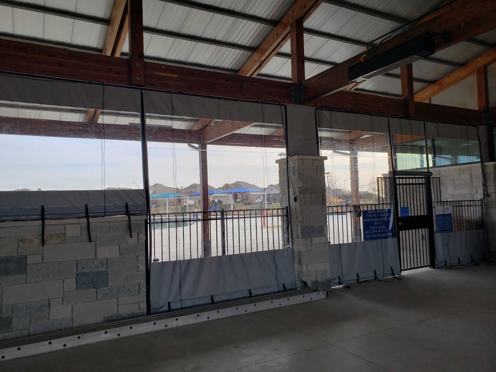 After: the pool-gate wall with the steel door and clear panels either side
