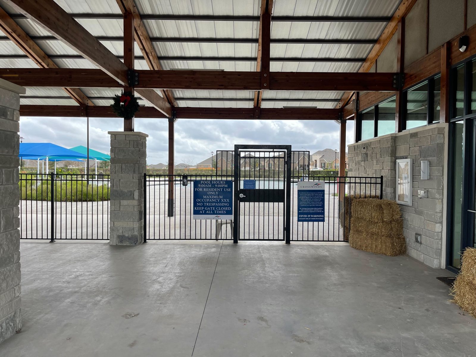 Before: the pavilion in December 2021, the pool gate open to the wind, nothing between the beams and the stone