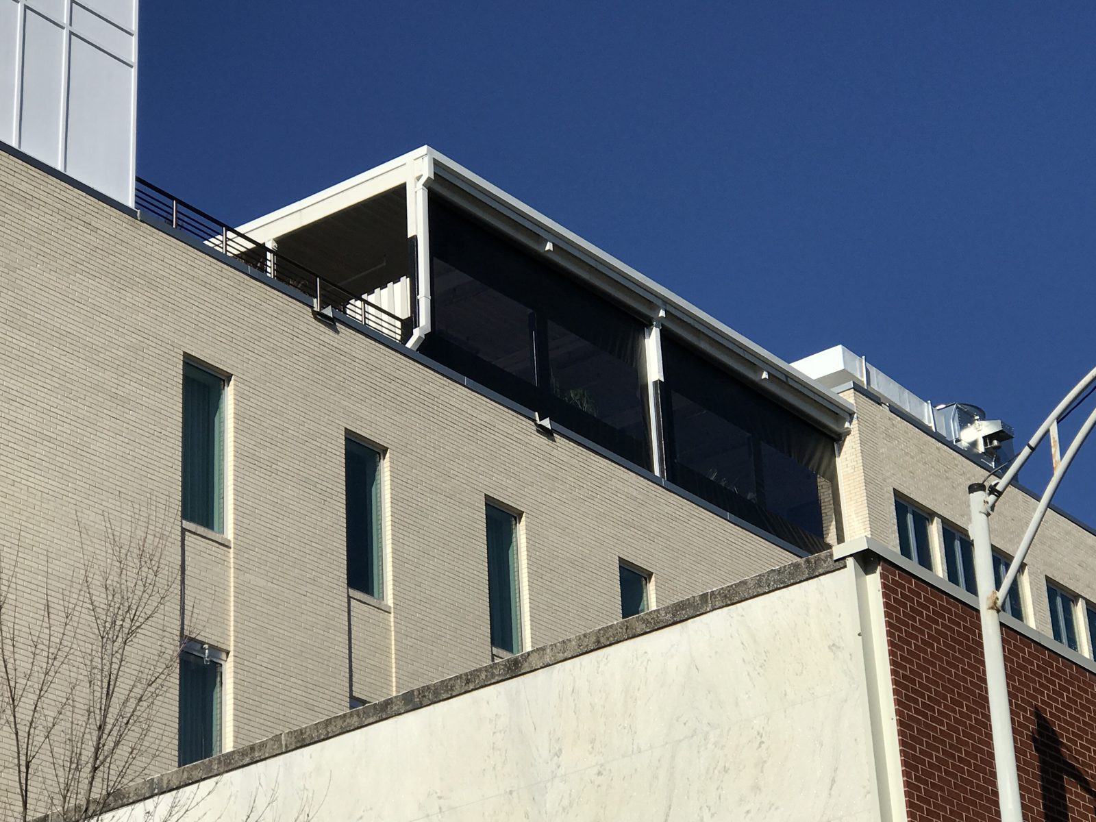 The Durham rooftop from the street: the black screens across the bays under the white canopy