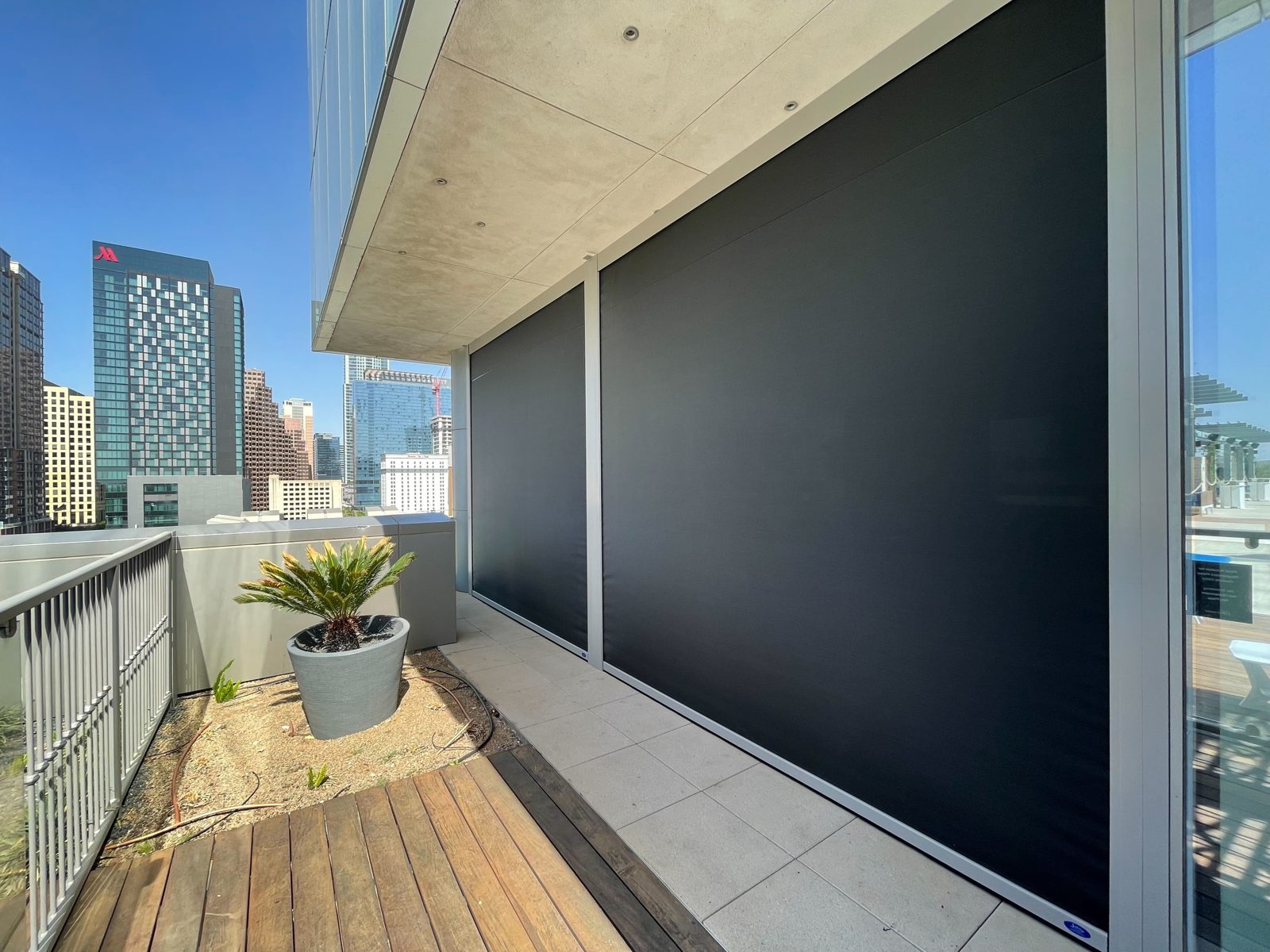 Fairmont Austin: two black motorized sun shades down on the rooftop terrace, downtown Austin behind the rail