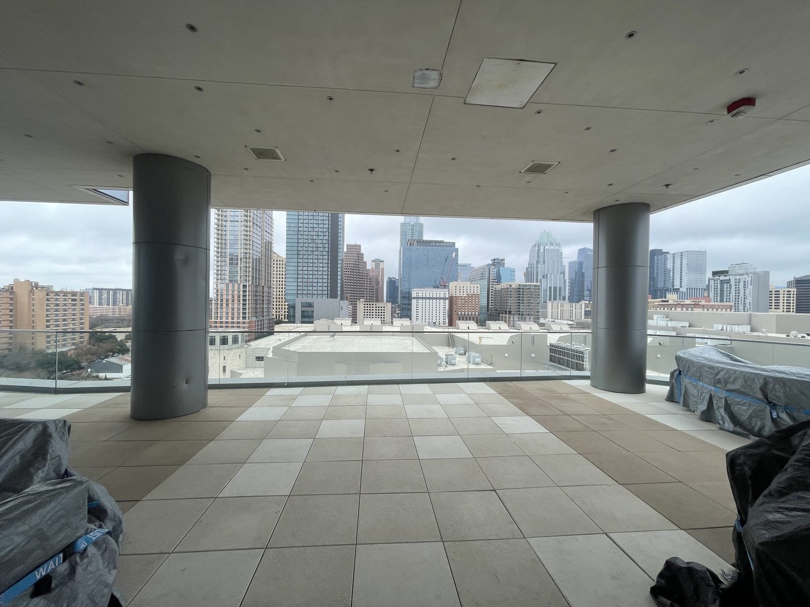 Before: the open rooftop terrace in January 2022, columns and the skyline, nothing in the openings