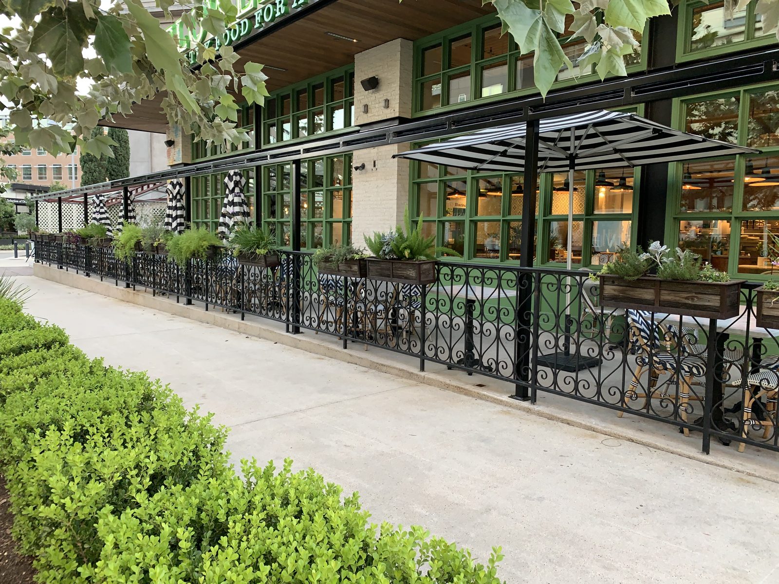 Before: the open patio along the storefront in September 2020, planters on the rail and nothing in the openings