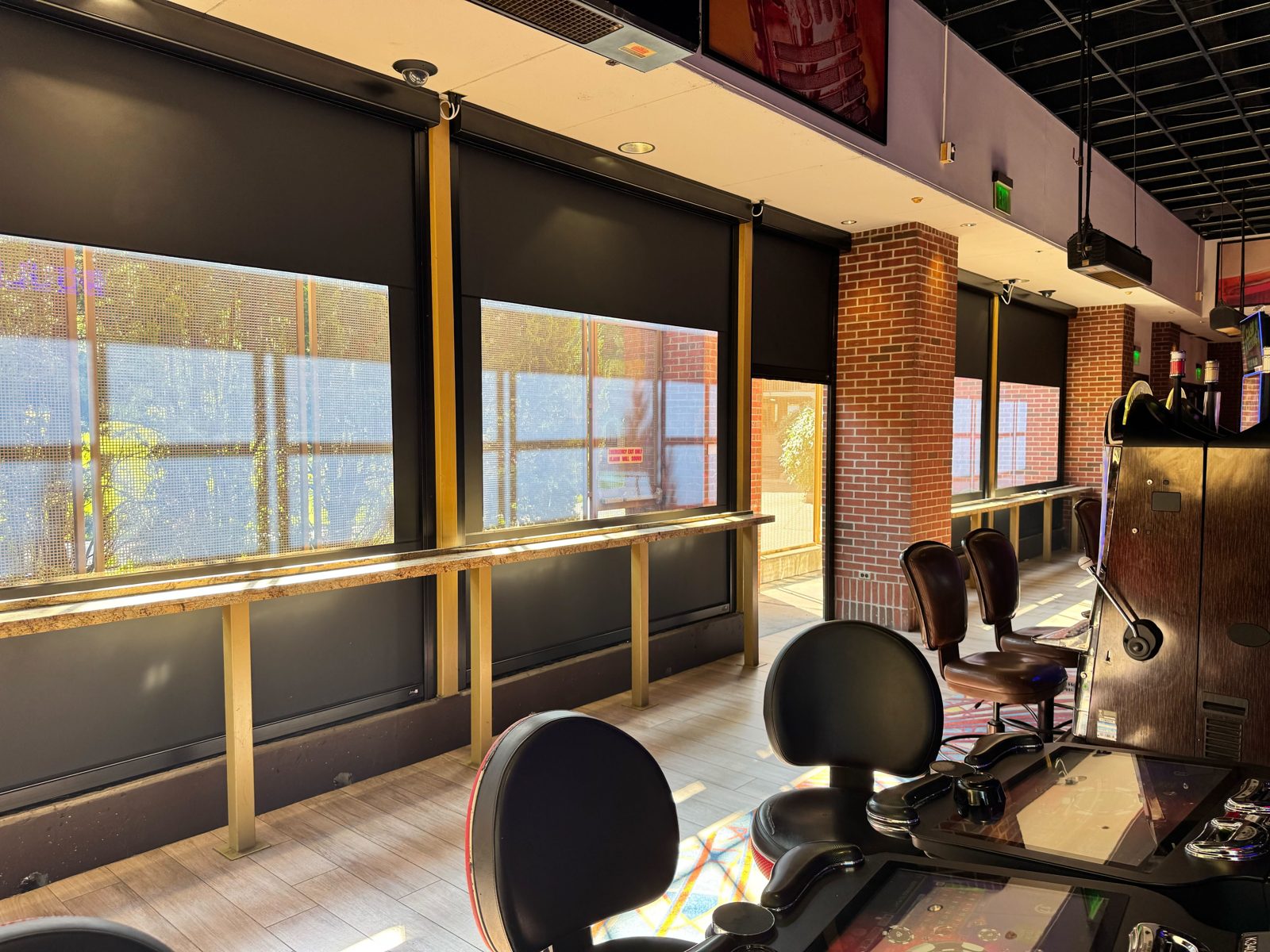 After: the East gaming patio with the new black shades down in the afternoon sun