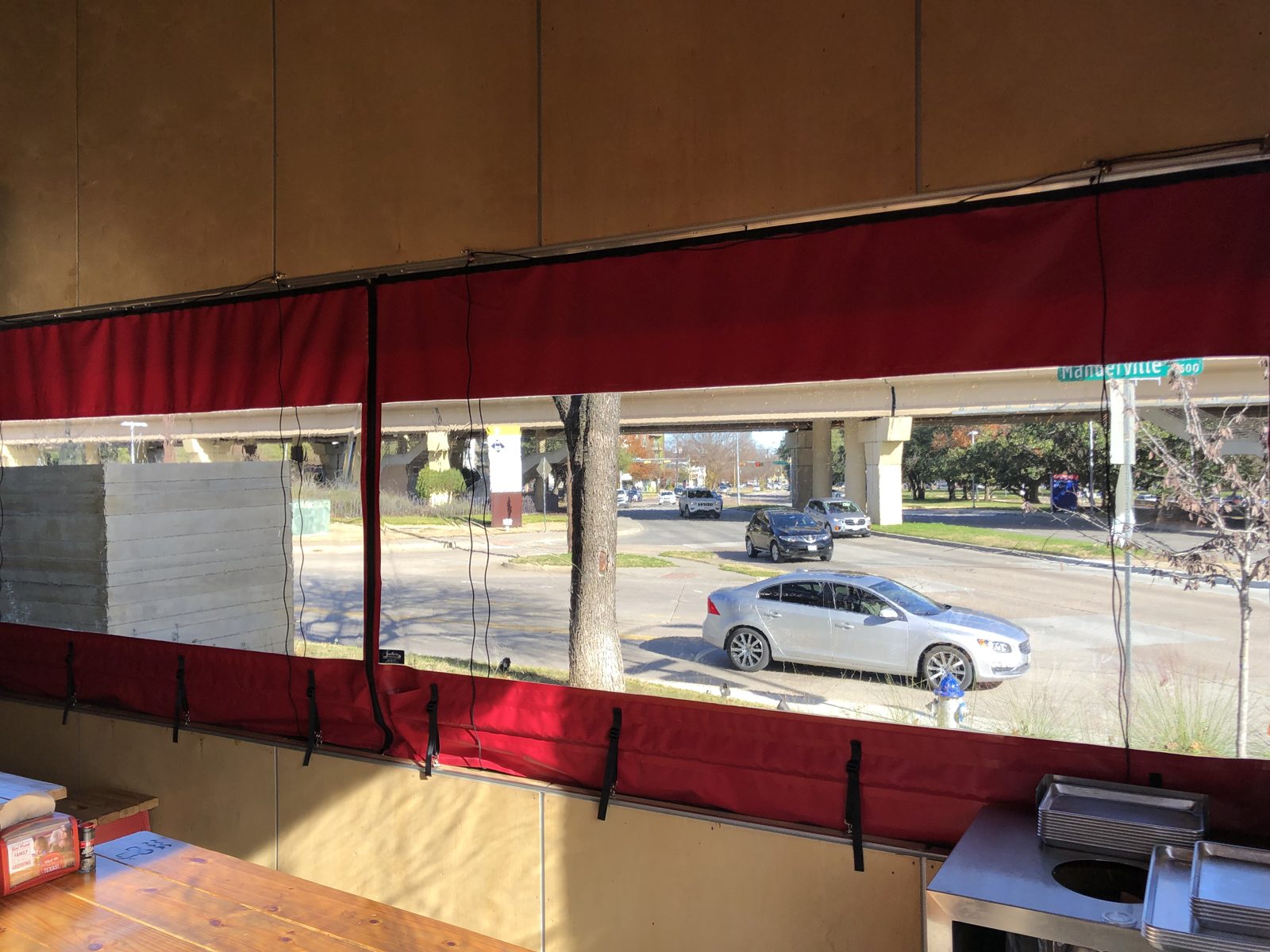 After: Hat Creek on The Hill in Dallas, the clear panels down over the counter rail with the street beyond