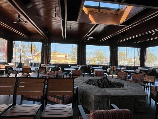 Inside Lazy Dog Henderson, Nevada: the firepit and lodge chairs with the clear panels closed on every side