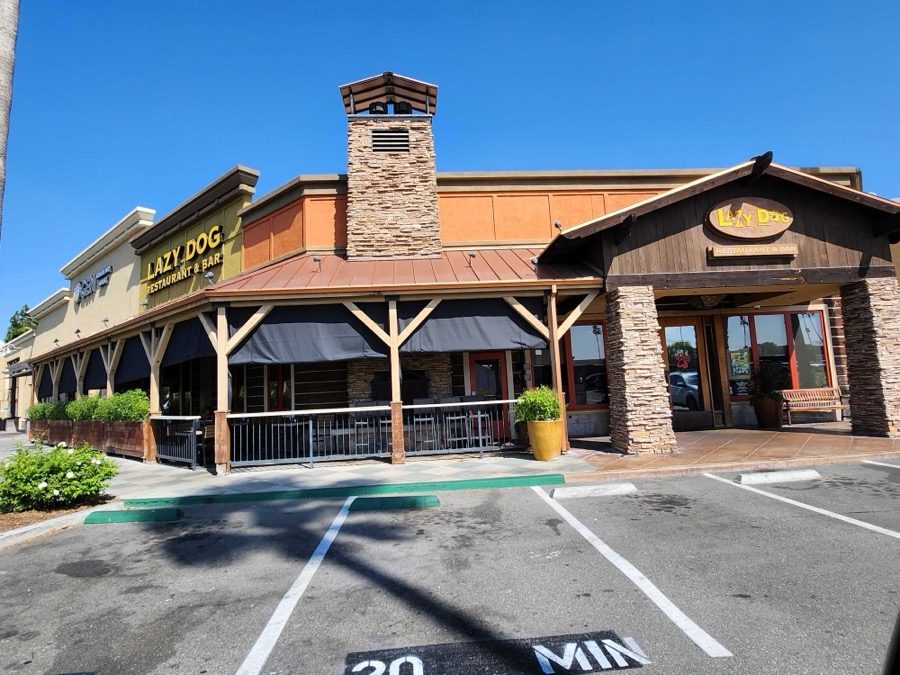 Lazy Dog Huntington Beach: the sun shades rolled up into the hoods under the timber, the patio open to the parking lot
