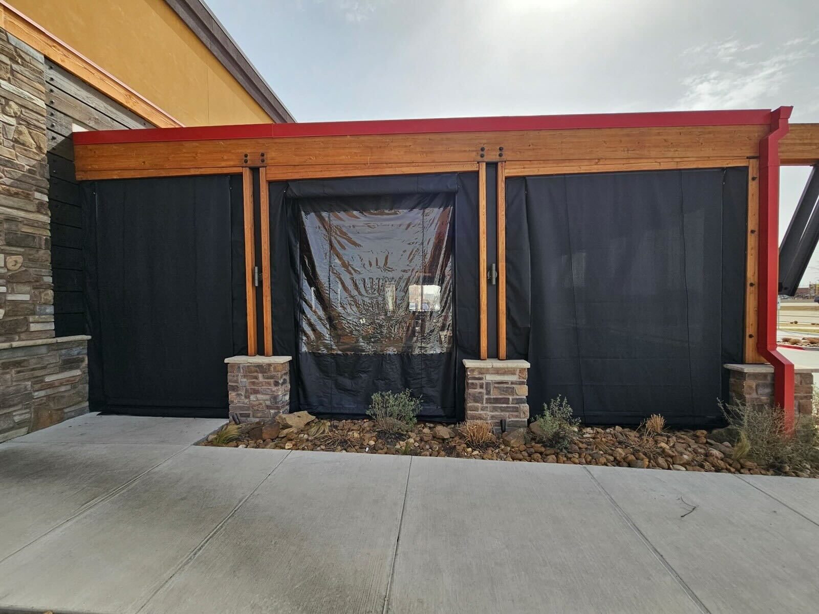 Lazy Dog Garland, Texas: black mesh sun shades down across the west bays with the clear panel at the door