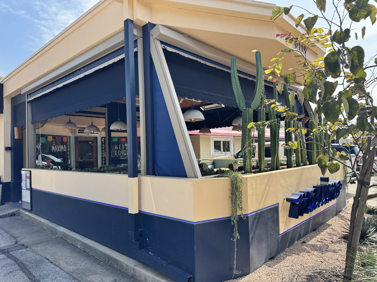 Maximo in West University Place: the corner patio with the navy motorized curtains rolled up under the awning, cactus planter at the corner