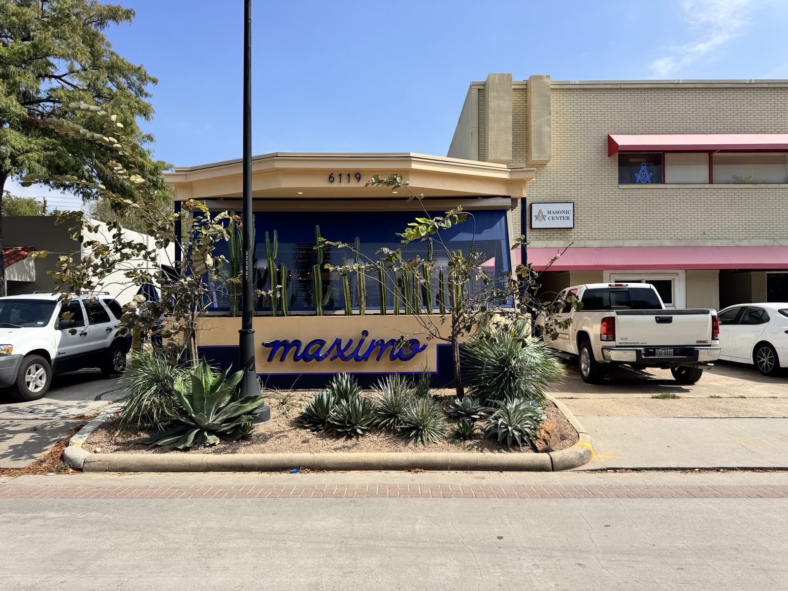 Maximo from across Edloe Street, the sign in the planter and the navy curtains in the openings