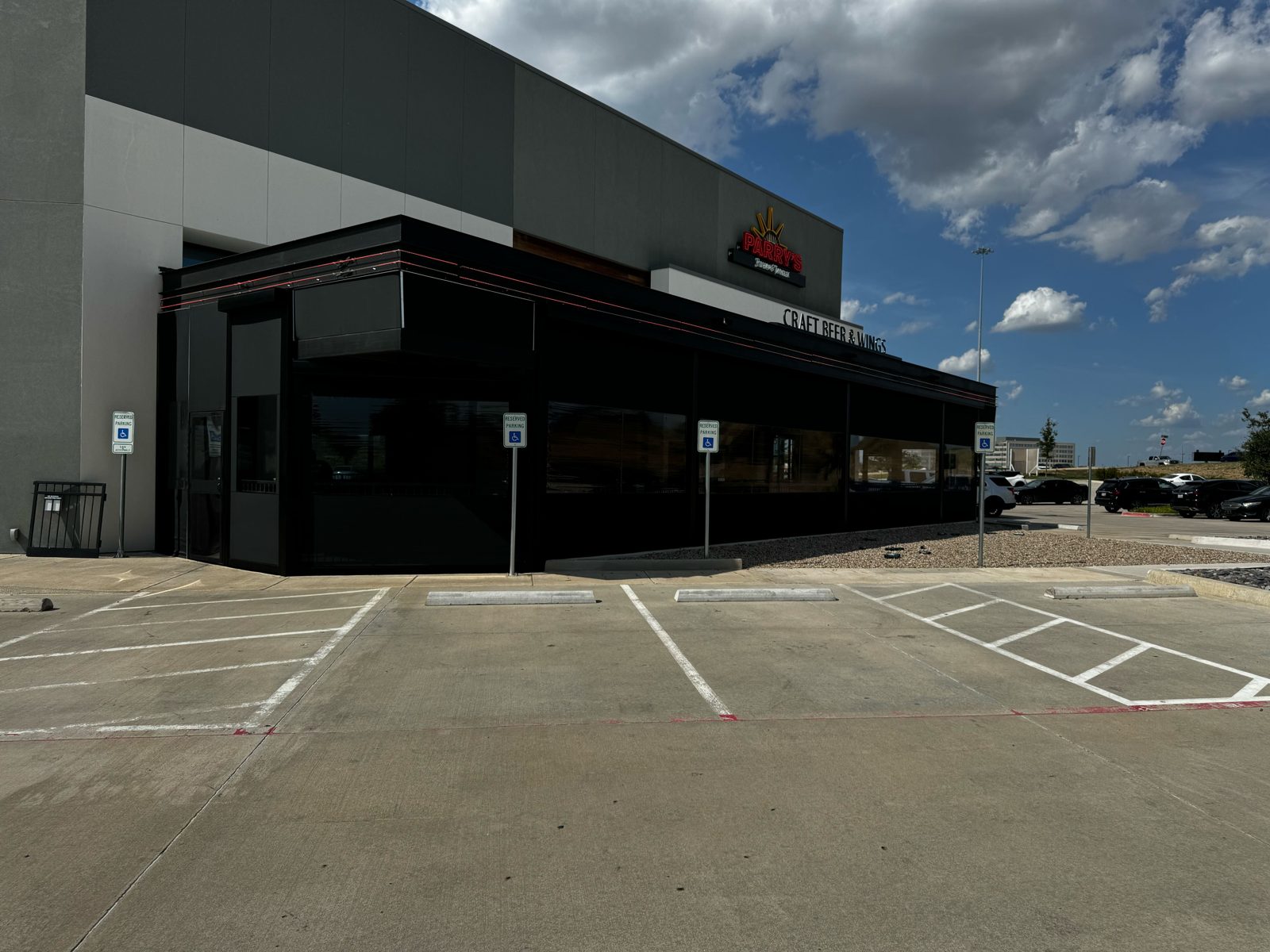 Parry's Pizzeria & Taphouse Fort Worth: the black motorized enclosure wrapping the corner patio under the Craft Beer and Wings sign