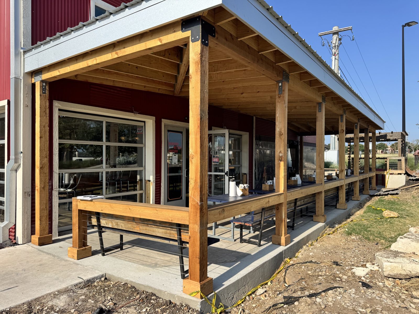 Before: the open Georgetown porch in 2025, timber posts and tables with nothing between them and the lot
