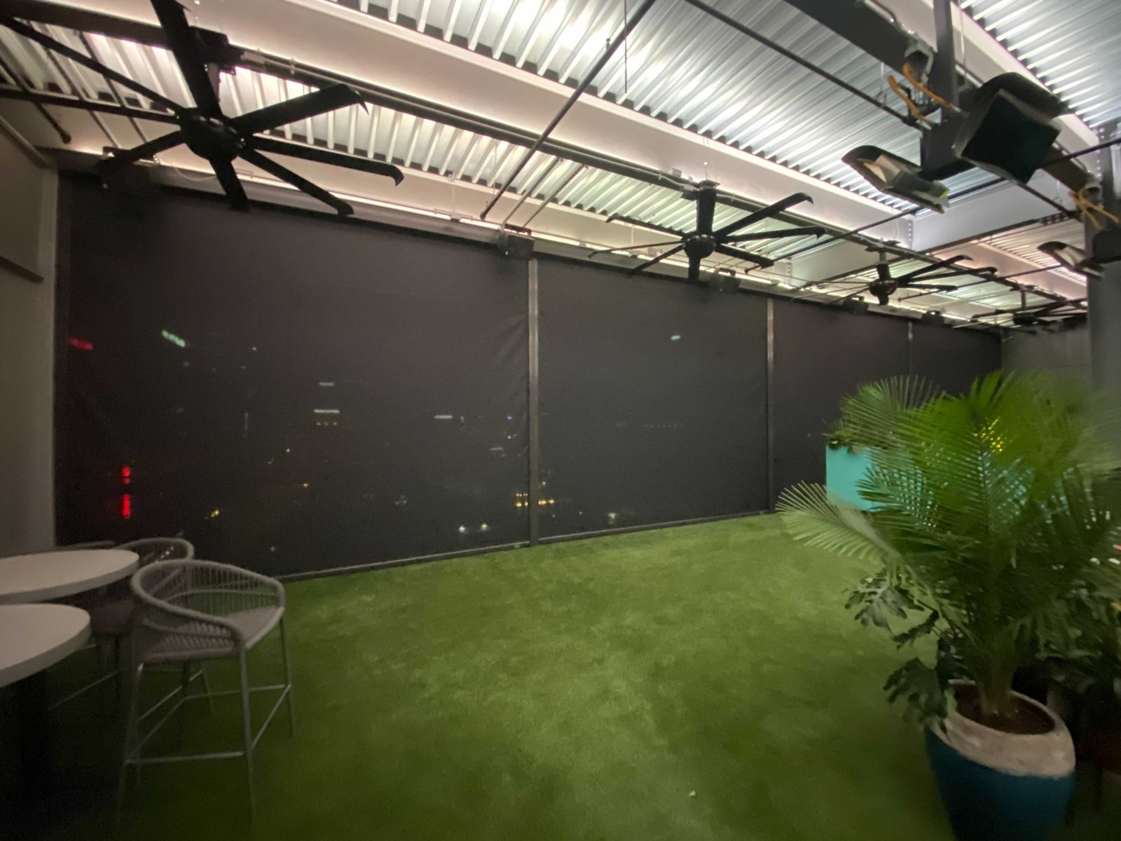 Zanzibar at the Austin Marriott Downtown: four black mesh sun shades down across the rooftop at night, the city lights through the mesh