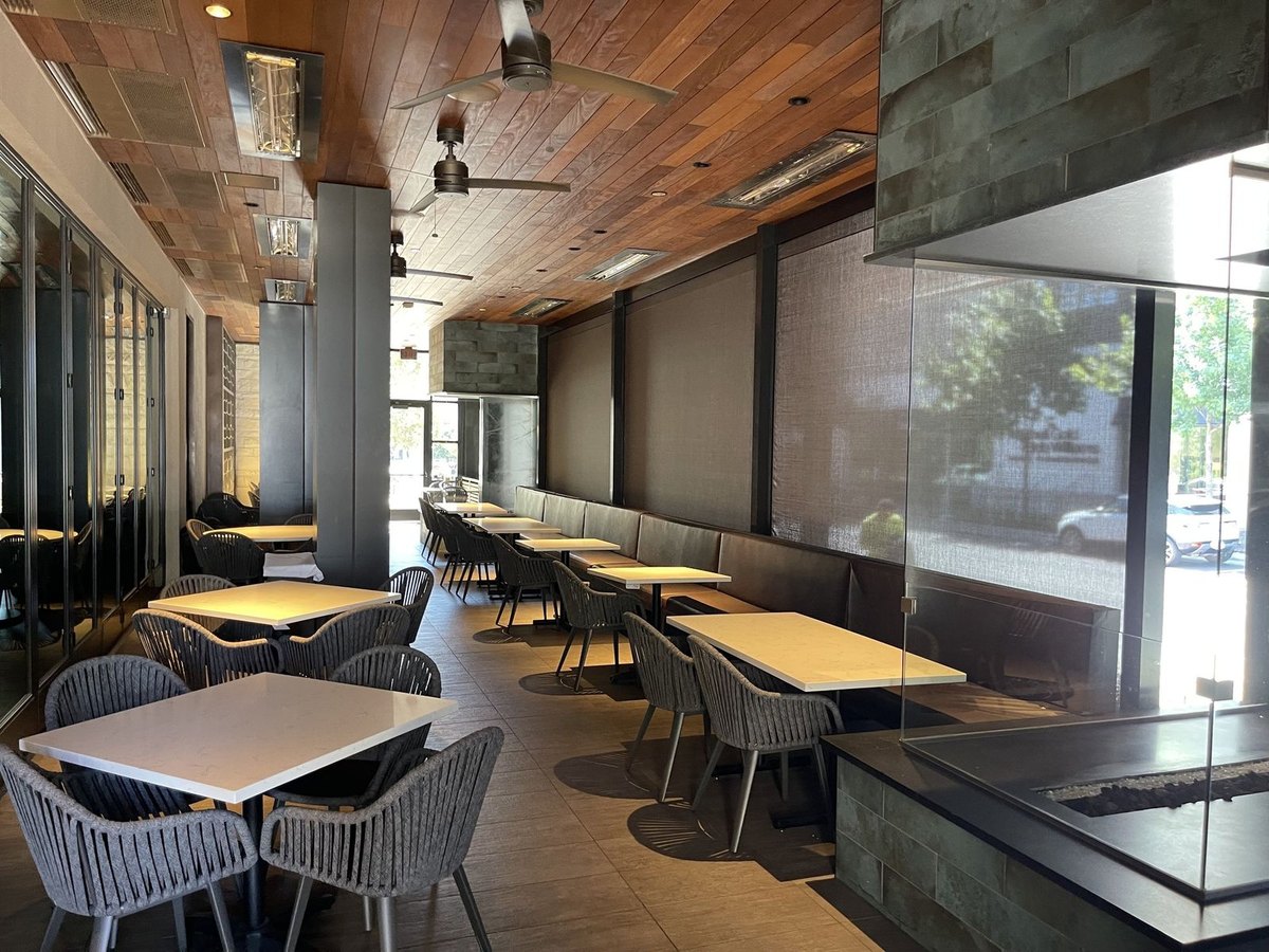 Perry's Steakhouse & Grille, Austin TX — patio dining room with motorized sun shades down along the booths