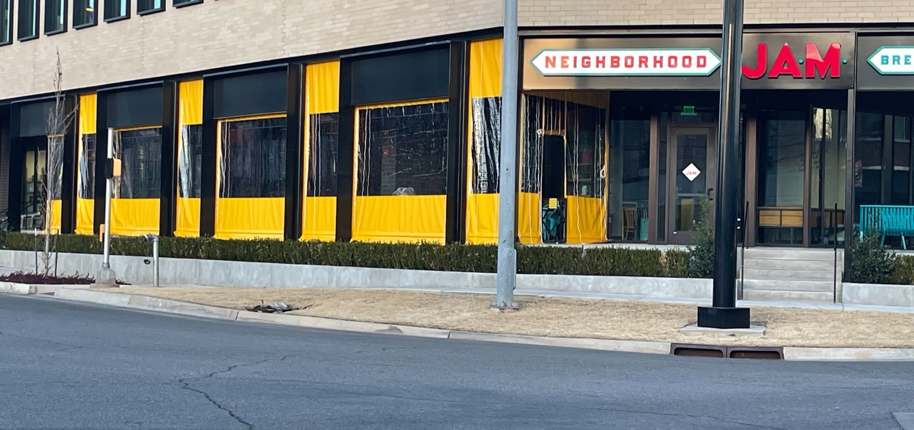 Neighborhood Jam, Midtown Oklahoma City: manual roll clear panels with yellow borders along the street side