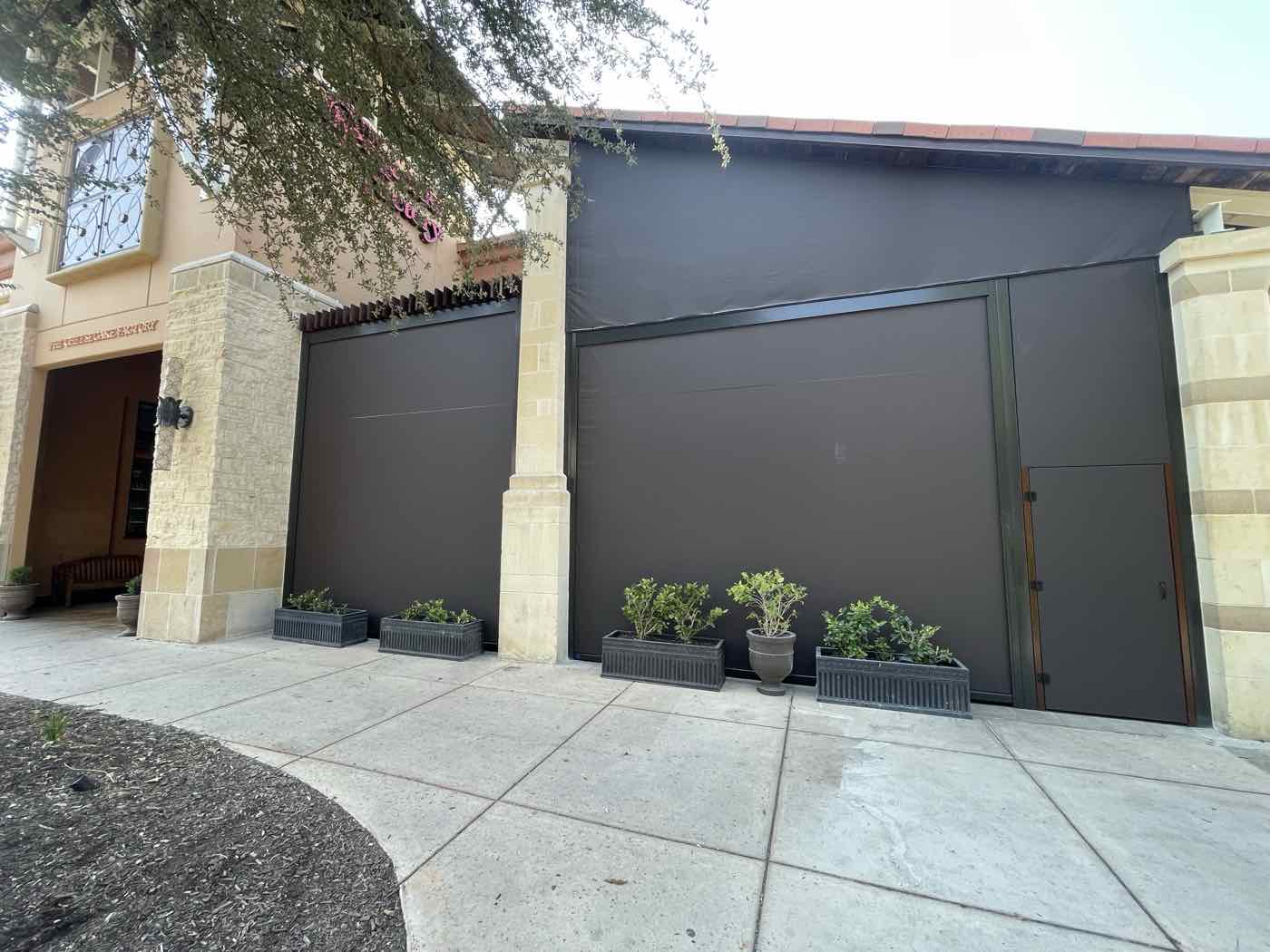 The Cheesecake Factory, La Cantera, San Antonio, Texas: motorized black roll screens across the storefront patio