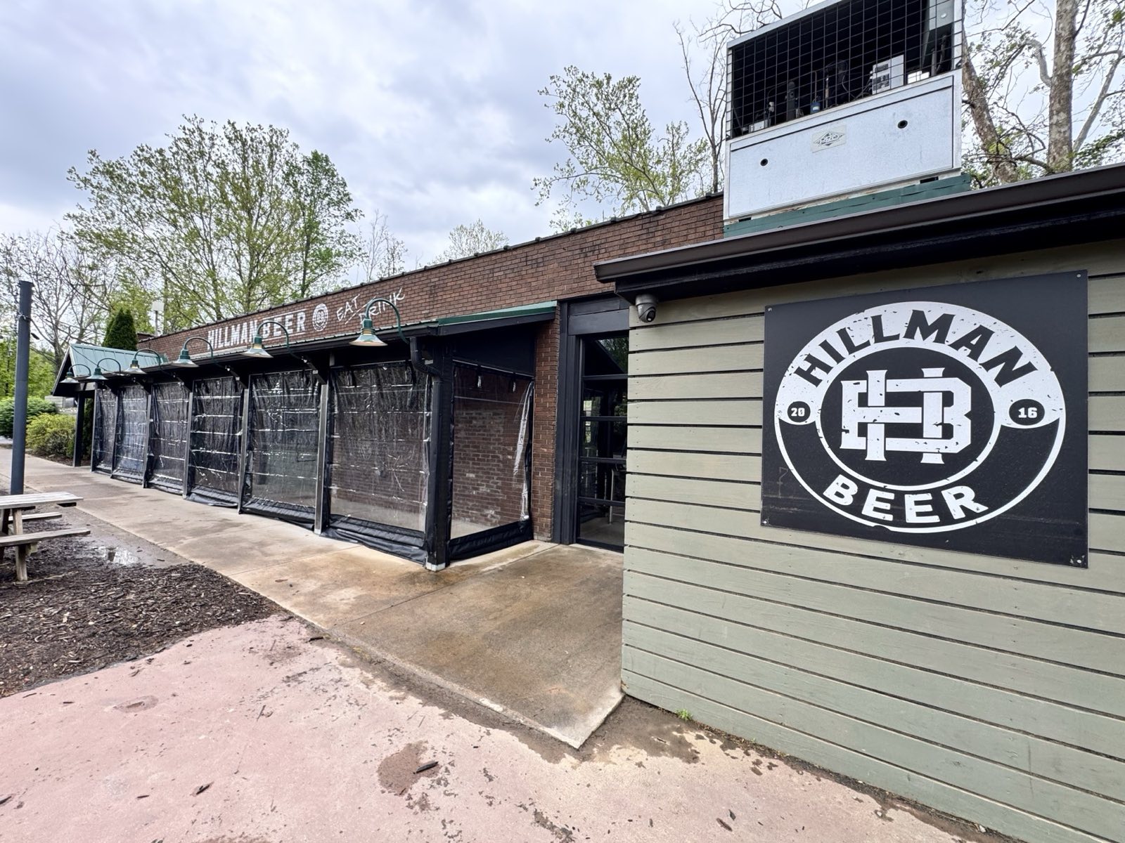 Hillman Beer, Asheville, North Carolina: manual roll-down enclosure in black solid and clear vinyl along the brewery patio