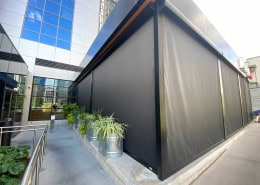 North Italia – Motorized Nano 97 Sun Shades Motorized Nano 97 black sun shades installed at North Italia by Southern Patio Enclosures – black hood, side tracks, vinyl panels and bottom bar. One-way visibility: blocks view from outside during daylight while allowing guests to see out; reverses at night