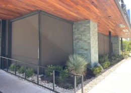 Perry’s Steakhouse & Grille Austin – Motorized Nano 97 Tobacco Sun Shades Motorized Nano 97 Tobacco sun shades installed at Perry’s Steakhouse & Grille in Austin, Texas by Southern Patio Enclosures – premium motorized retractable shades with clean black tracks and hardware on the modern stone-and-wood facade